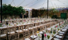 Bignor Park weddings courtyard reception tables and white chairs set up with overhead canvas